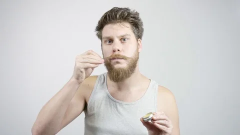 The bearded guy has been laying his mustache.Styling moustache wax 動画素材 121687975