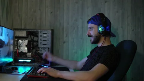 A bearded guy with headphones plays computer games. Cybersportsman at home Stock-Footage 149215223