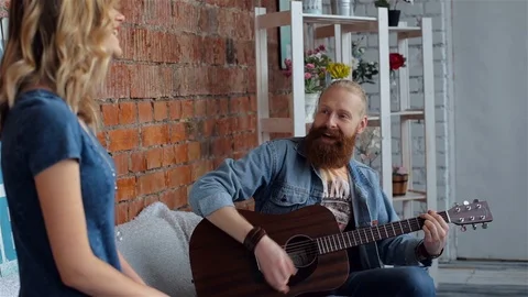 The bearded guy plays the guitar. The guy and the girl are singing Stock Footage 87957141