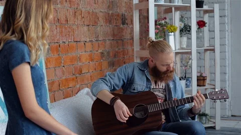 The bearded guy plays the guitar. The guy and the girl are singing Stock Footage 88058464