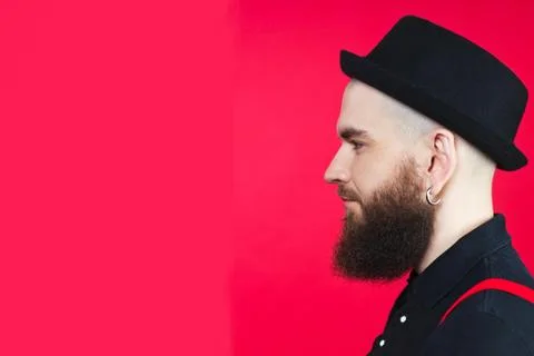 A bearded guy in profile. Bearded guy on a red background Stock Photos