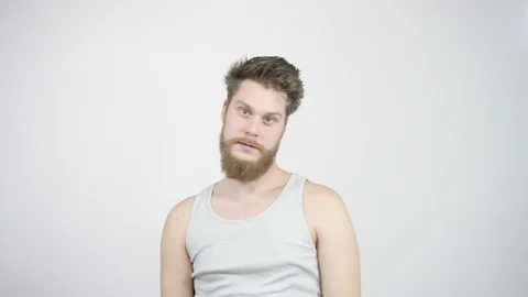 Bearded guy shows his middle finger at the camera and smiling 動画素材 121687872