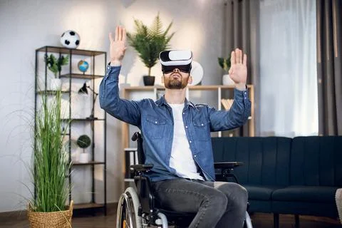 Bearded guy with special needs using virtual headset at home 스톡 사진