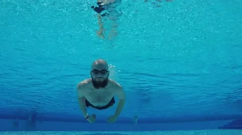 The bearded guy is swimming in the pool. Cheerful guy in the pool Stock Footage 68696614