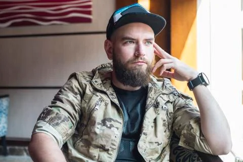 A bearded guy. Thoughtful bearded guy indoors. Stock Photos