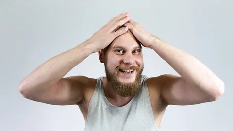 Bearded Guy touches shaved head in front of the mirror and smiling. Stock Footage 121975402