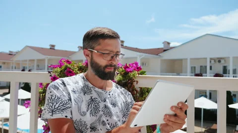 Bearded guy on vacation working on a tablet Stock Footage 130891978