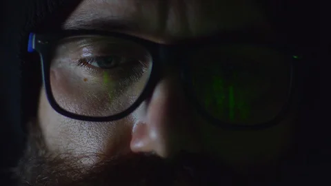 Bearded hacker in eyeglasses working on computer in the night green programming  Stock Footage 127183571