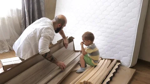 Bearded handsome father with son looking at the contents of the boxes for the Stock Footage 248349569