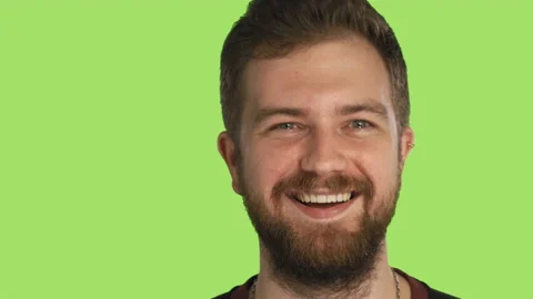 Bearded handsome man smiling and winking looking at camera isolated on green Stock Footage 150402182