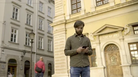 Bearded Handsome Man Typing Messages on his Smartphone. Wearing stylish clothes Stock Footage 146396321