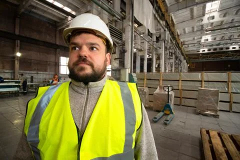 Bearded handsome smiling engineer worker, helmet and vest Stock Photos