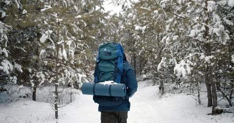 Bearded hiker with backpack walking through winter forest Stock Footage 125159701