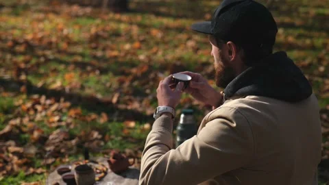 Bearded hipster in a cap drinks tea from a bowl outdoors. chinese tea cerem.. Stock Footage 229858911