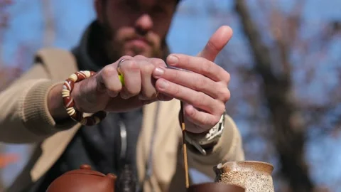 Bearded hipster ignites incense stick with lighter. outdoors tea ceremony Stock Footage 229858354