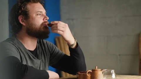 Bearded hipster man drinking chinese tea from a clay bowl. tea ceremony Stock Footage 146884340