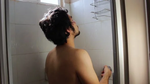 Bearded Hispanic young man taking a relaxing bath in the bathroom shower Video stock 132530092