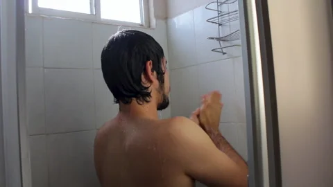 Bearded Hispanic young man taking a relaxing bath in the bathroom shower Video stock 132541622