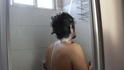 Bearded Hispanic young man taking a relaxing bath in the bathroom shower Video stock 132544185