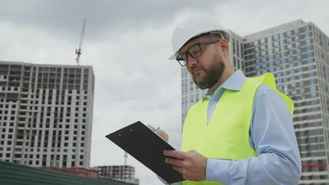 Bearded inspector at construction site making notes on paper Stock Footage 219778010