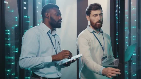 Bearded IT engineer with system administrator opening server rack cabinet Video stock 119232525