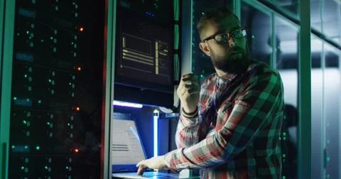 Bearded IT specialist setting servers in data center Stock Photos