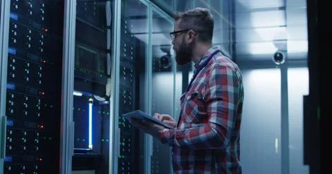 Bearded IT specialist setting servers in data center Stock Photos