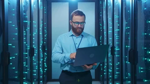Bearded IT specialist turning off server room smiling badly at camera hackering Stock Footage 120794714