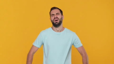 Bearded mad upset young man 20s in basic casual blue t-shirt isolated on yellow Stock Footage 148288460