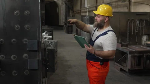 Bearded male engineer checking industrial furnace machine Vídeo Stock 334723327