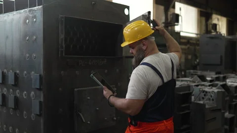 Bearded male engineer checking industrial furnace machine Video stock 334723355