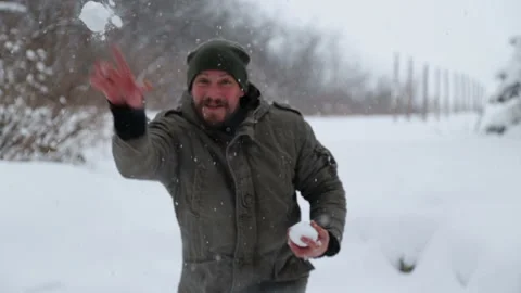 Bearded male throws a snowball into the camera. Stock Footage 102160458