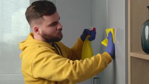 Bearded mam is cleaning the house using gloves and special disinfecting spray Stock Footage 146135547
