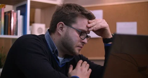 A bearded man is actively working and trying to talk on the phone Stock Footage 87323997