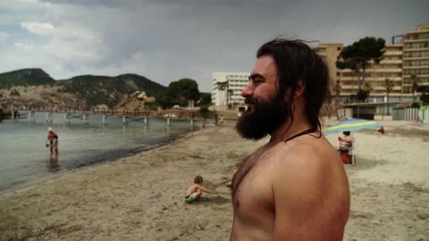 Bearded man on an almost empty beach due to the new normal situation after co Video stock 131172492