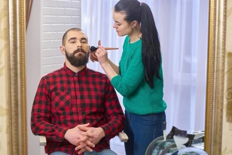 Bearded man and makeup artist. Photos