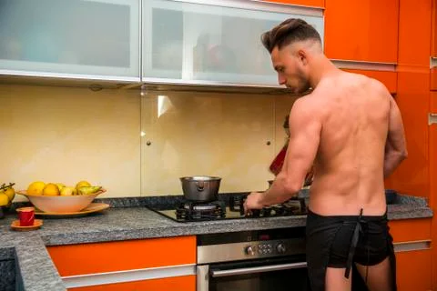 Bearded man in apron preparing breakfast Stock Photos