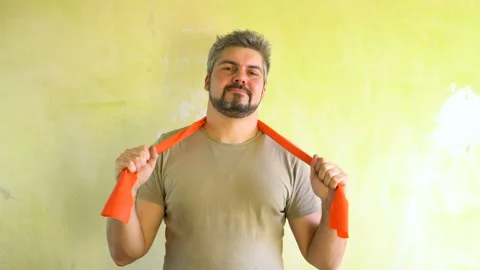 Bearded man on the background of the wall. Holds a sports elastic band in ha Stock Footage 124626458