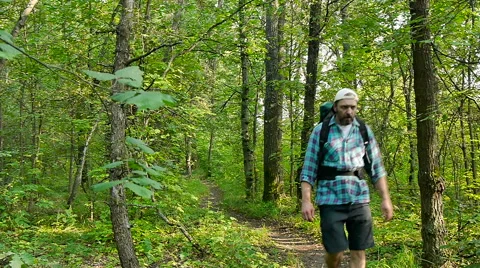 A bearded man with a backpack walking along the trail Stock Footage 65482848