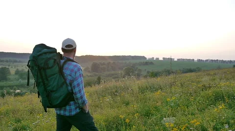 A bearded man with a backpack walking in the field Stock Footage 67425443