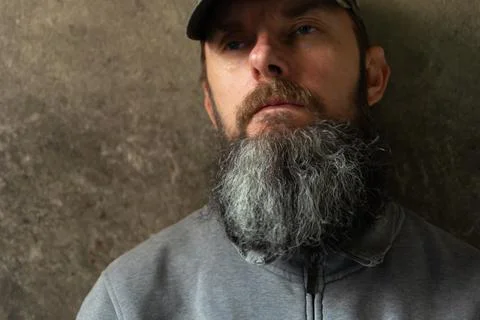 Bearded man in a baseball cap on the wall background Stock Photos