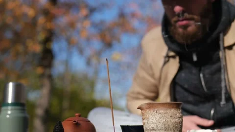 A bearded man with a beard blows out an incense stick. chinese tea ceremony Stock Footage 229858346