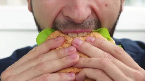 Bearded man bites delicious burger eat fast food soft focus Stock Footage 135885423