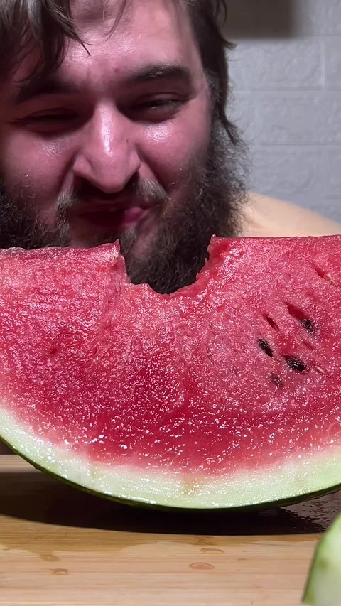 Bearded man bites slice of fresh juicy red raw sweet watermelon Stock Footage 280482902