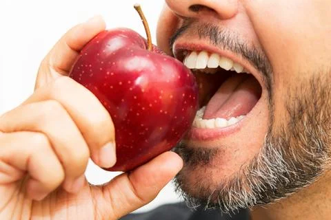 Bearded man biting an apple Stock Photos