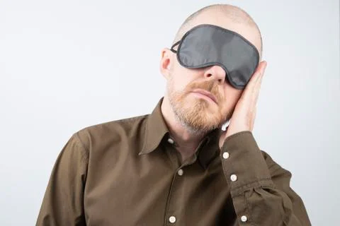Bearded man with a blindfold for sleeping Stock Photos
