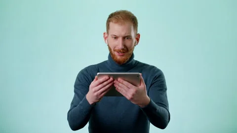 Bearded Man On Blue Background Watching A Sports Soccer Game On The Tablet Stock Footage 170190128