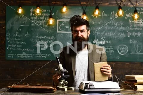 Bearded man with book and retro typewriter. Scientist make research with Stock Photos