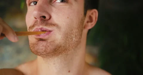 Bearded man brushes teeth with toothpaste in bathroom Video stock 210232338