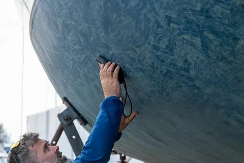 Bearded man checking boat hull with portable measuring device Stock Photos